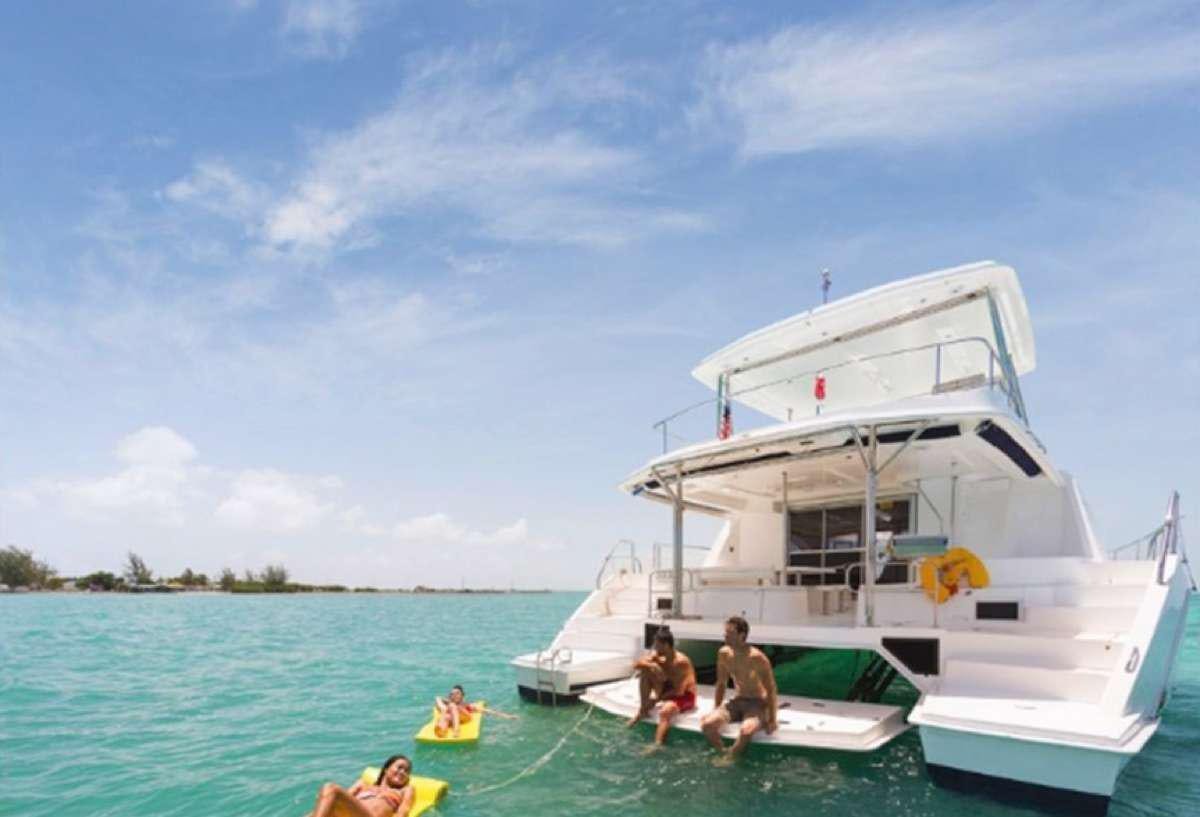 a group of people in a body of water next to a boat aboard JamSam Yacht for Charter