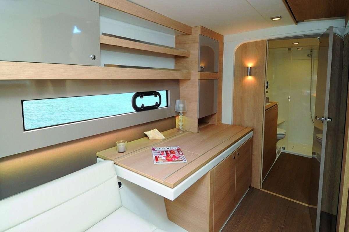 a room with a table and a tv on the wall aboard Barbara Jane Yacht for Charter