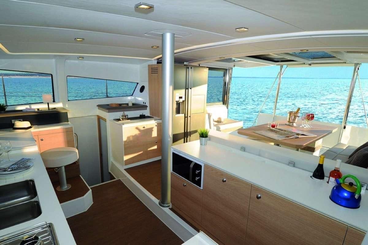 a room with a large window and a table with chairs and a large pool of water aboard Barbara Jane Yacht for Charter