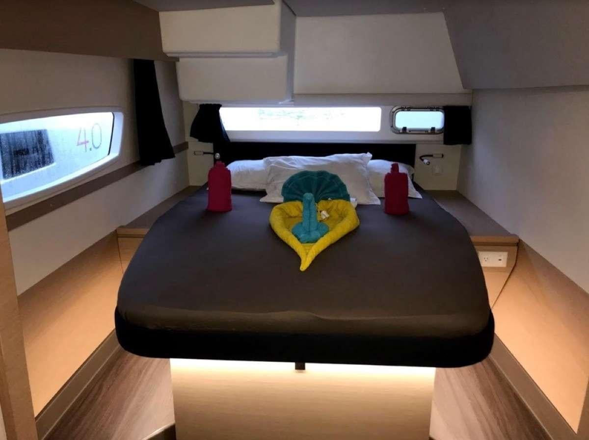 a bed with a blue blanket aboard Heliades Yacht for Charter