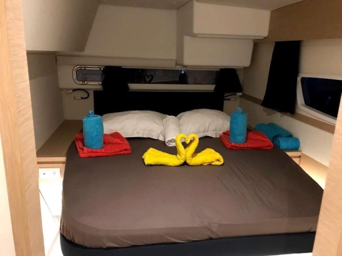 a bed with yellow and red towels aboard Heliades Yacht for Charter