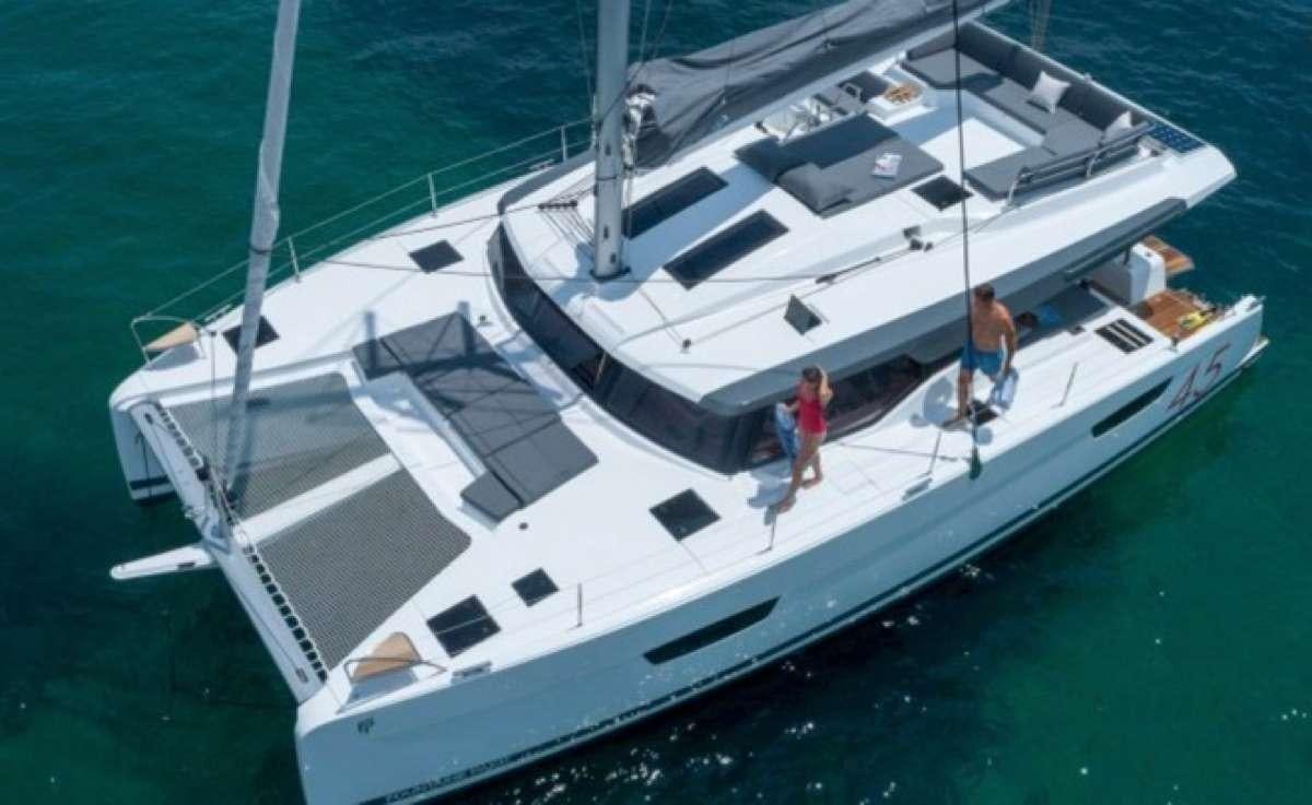 a white boat with a couple people on it aboard Game Changer Yacht for Charter