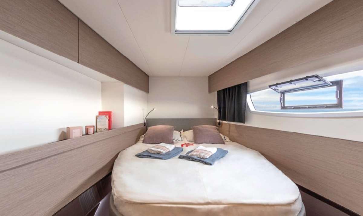 a room with a bed and a window aboard Game Changer Yacht for Charter