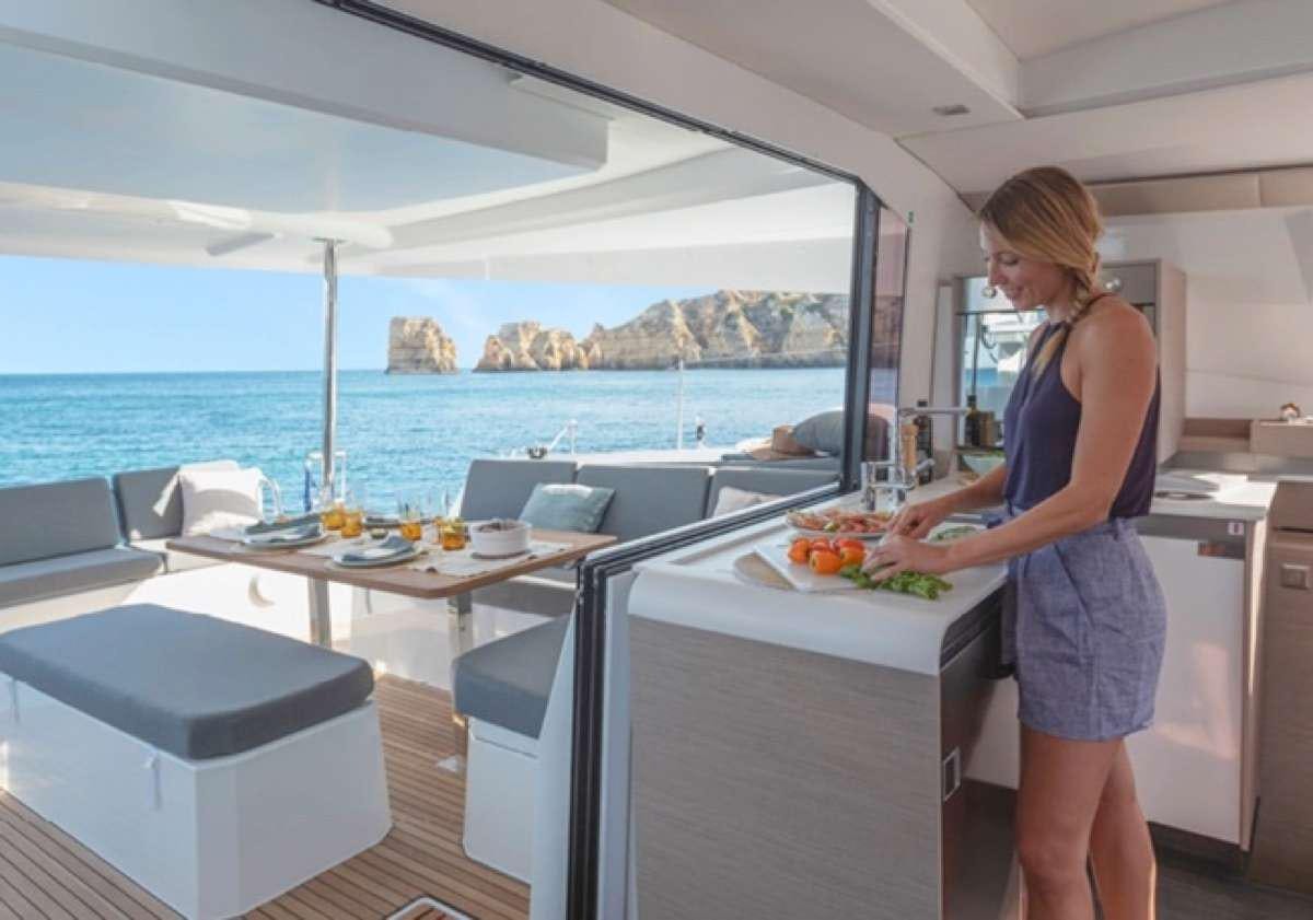 a woman standing in a kitchen aboard Game Changer Yacht for Charter