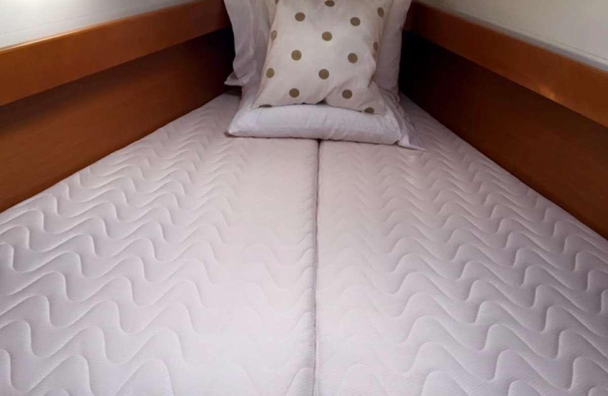 a bed with white sheets aboard Sea Wolf Yacht for Charter