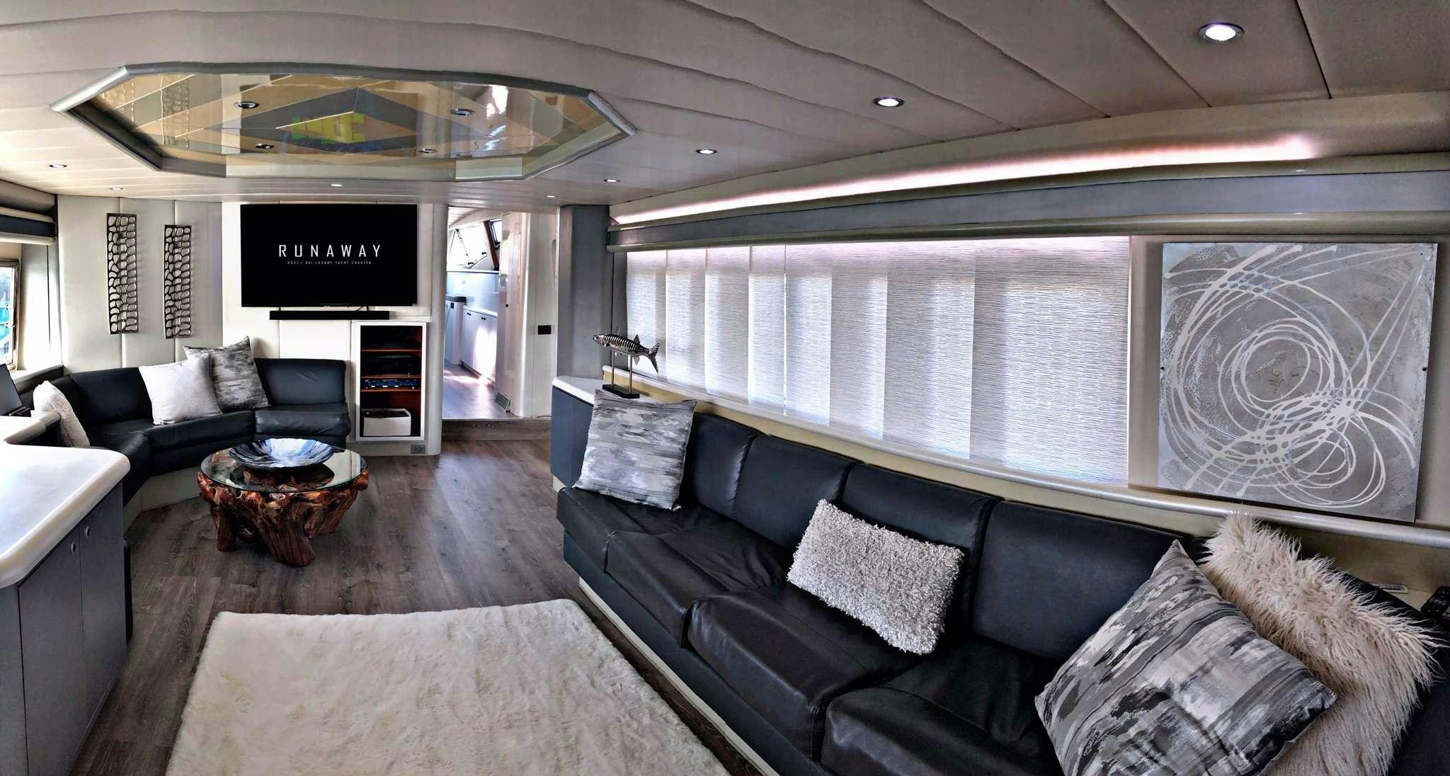 a living room with a couch and a television aboard RUNAWAY OF TORTOLA Yacht for Charter