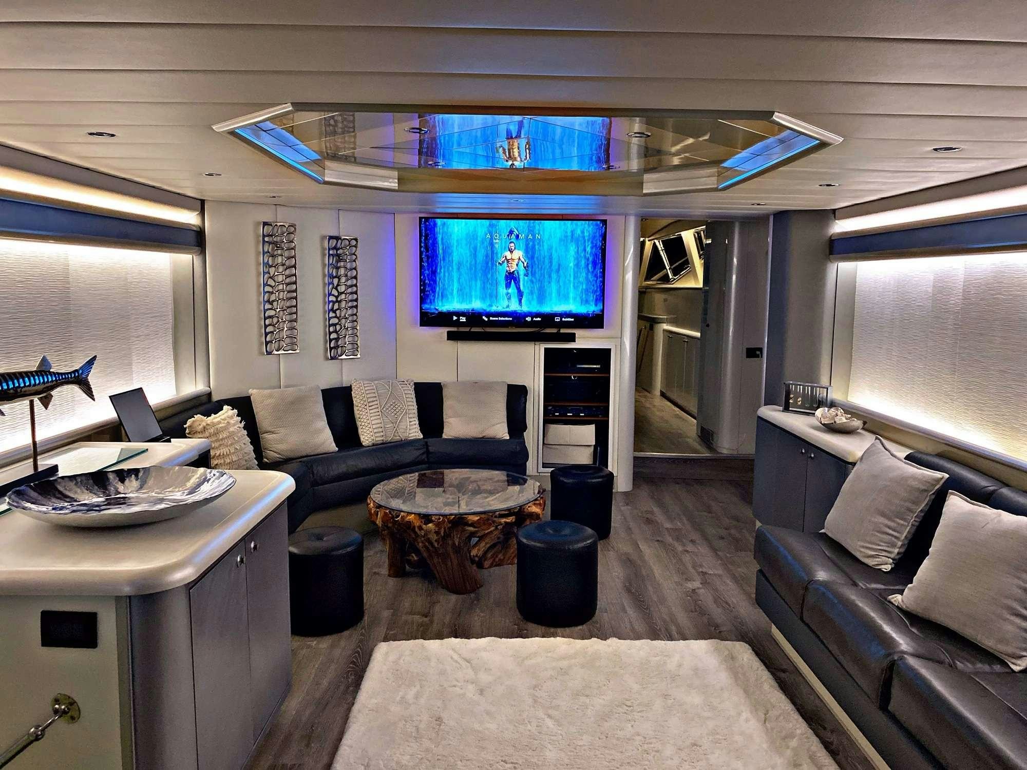 a living room with a large blue screen aboard RUNAWAY OF TORTOLA Yacht for Charter