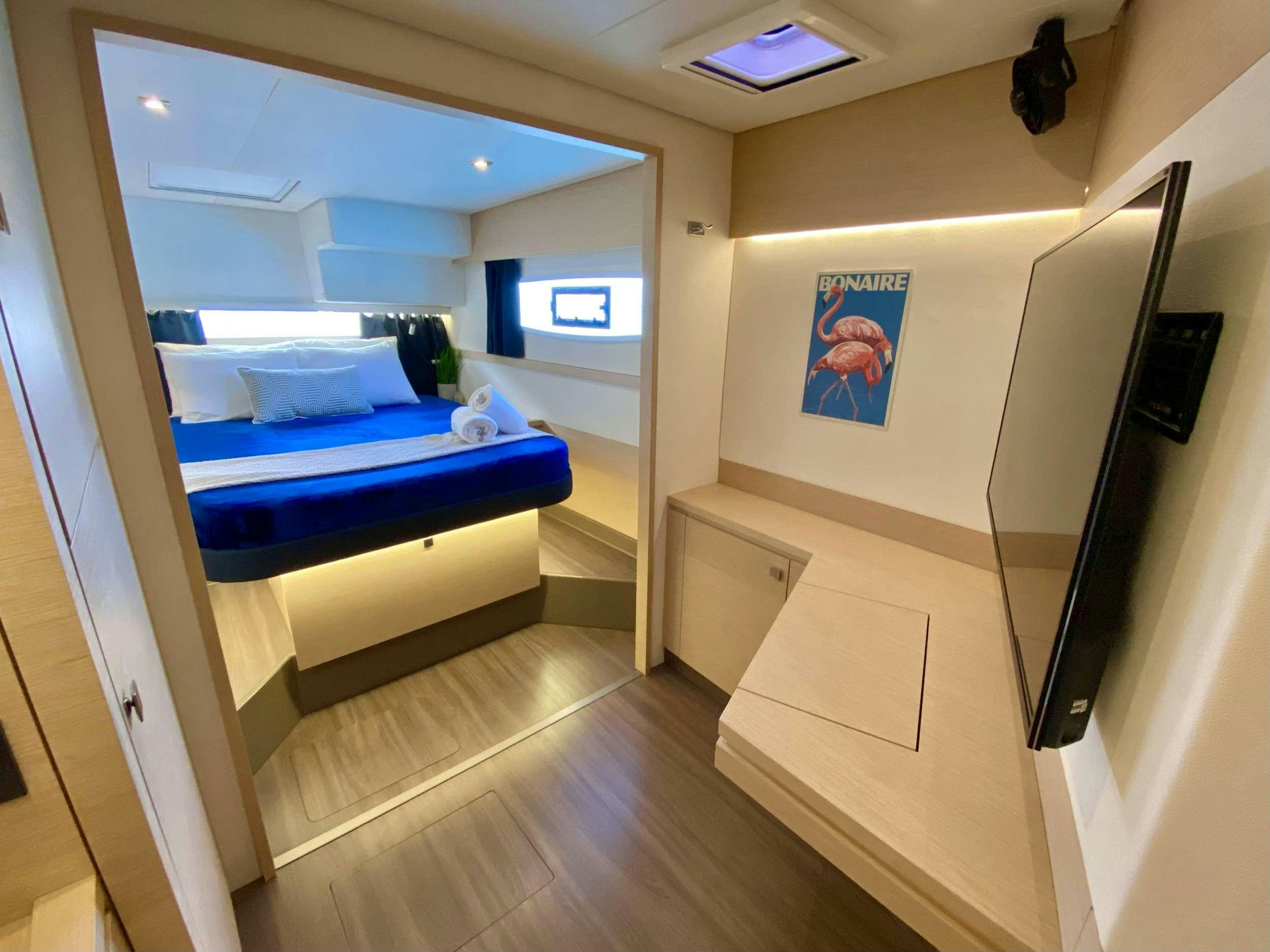 a room with a bed and a television aboard OCEANFRONT PROPERTY Yacht for Charter