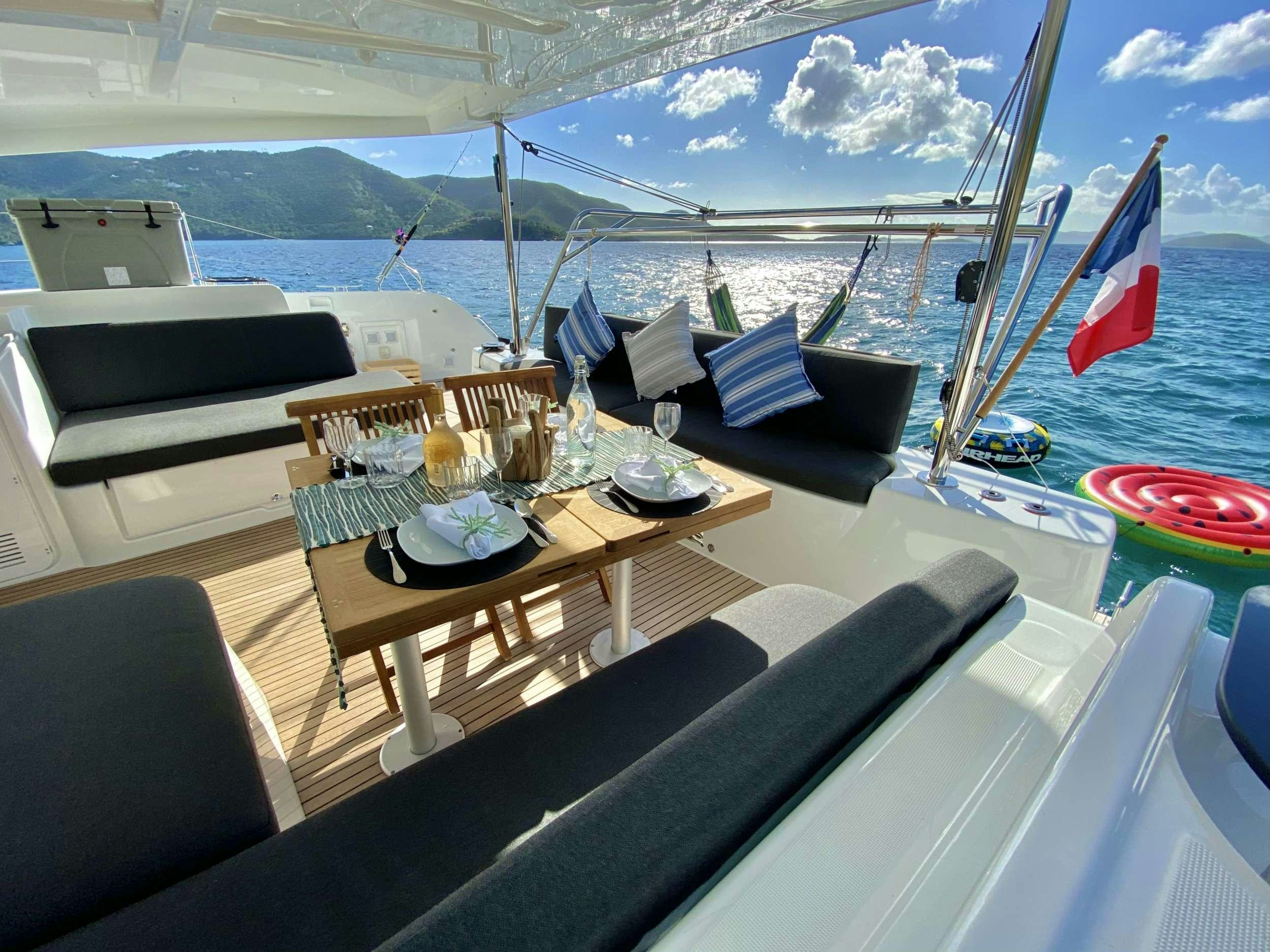 a table with chairs and a boat on it aboard RENDEZ-VOUS Yacht for Charter