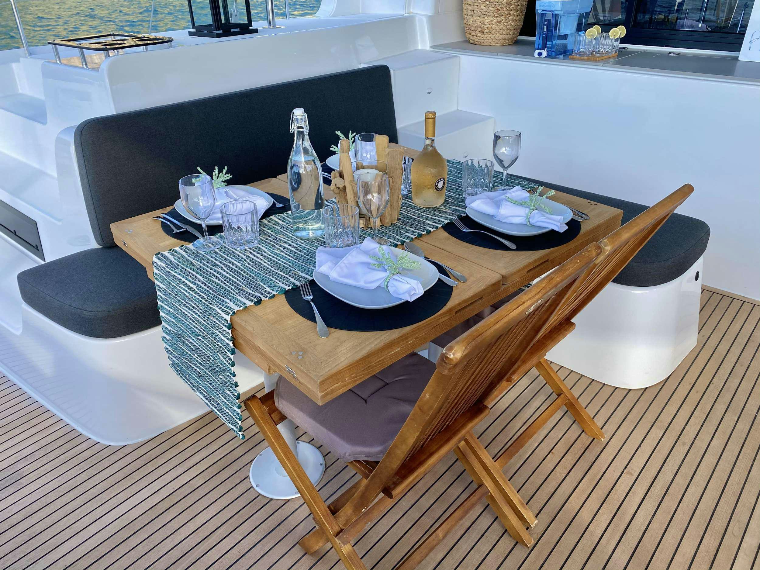 a table with plates and glasses on it aboard RENDEZ-VOUS Yacht for Charter