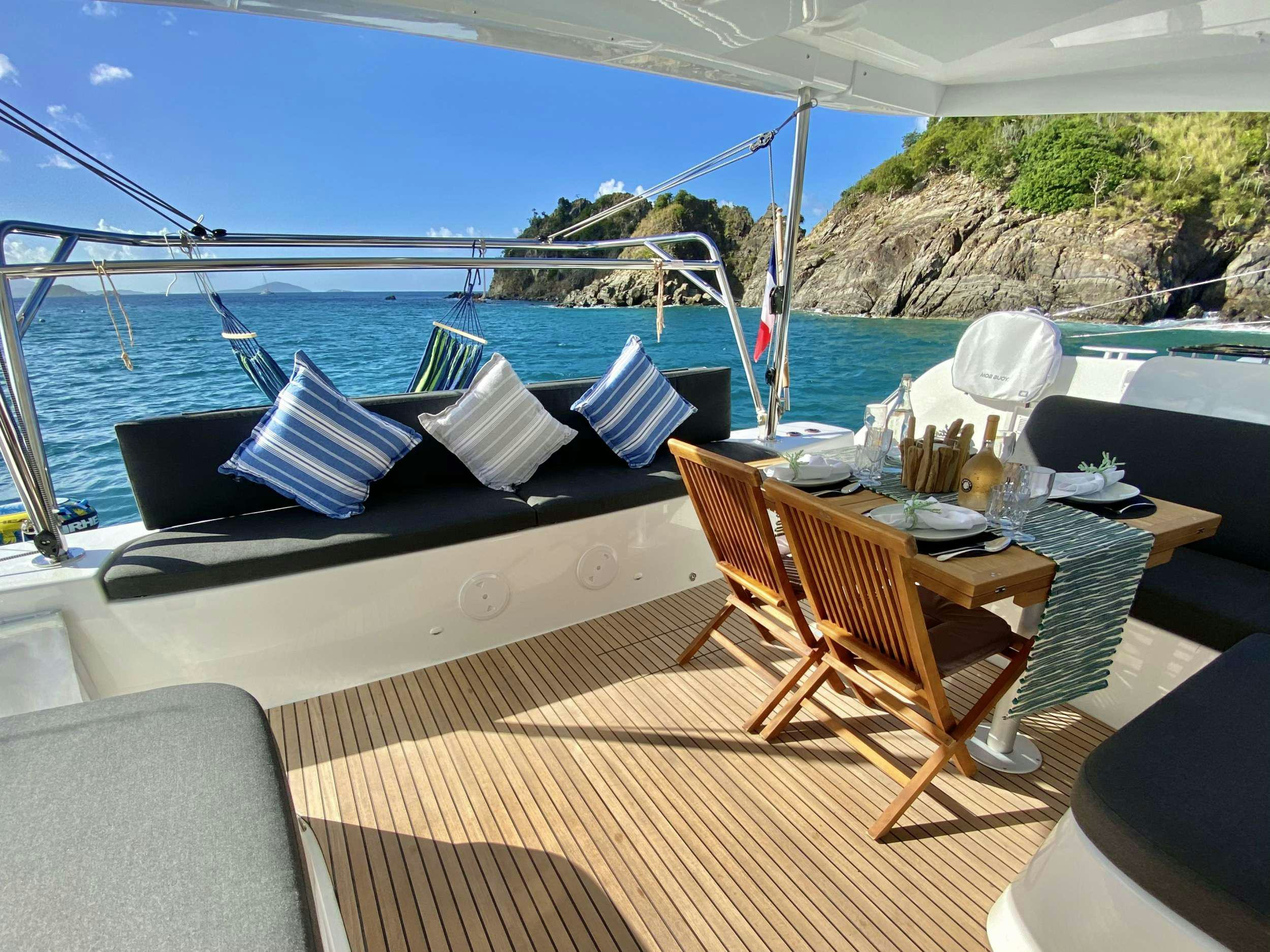 a deck with a table and chairs on it aboard RENDEZ-VOUS Yacht for Charter