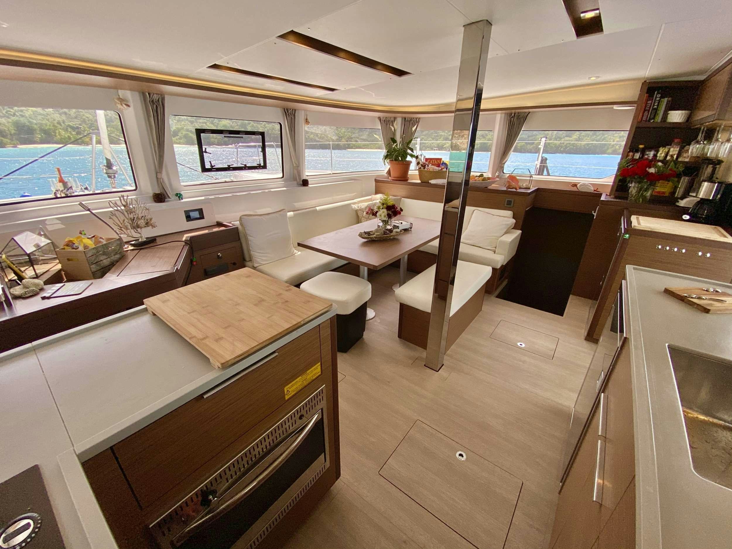 a room with a table chairs and a window aboard EASIR II Yacht for Charter