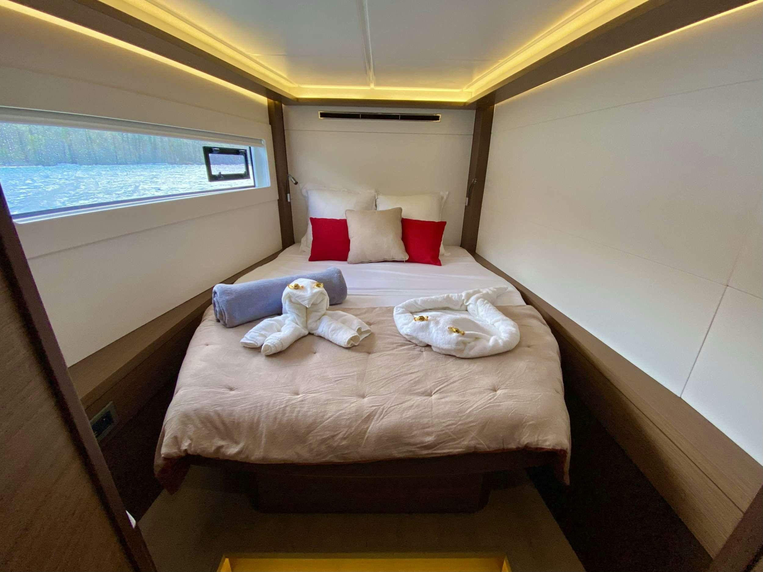 a bed with pillows and blankets aboard EASIR II Yacht for Charter