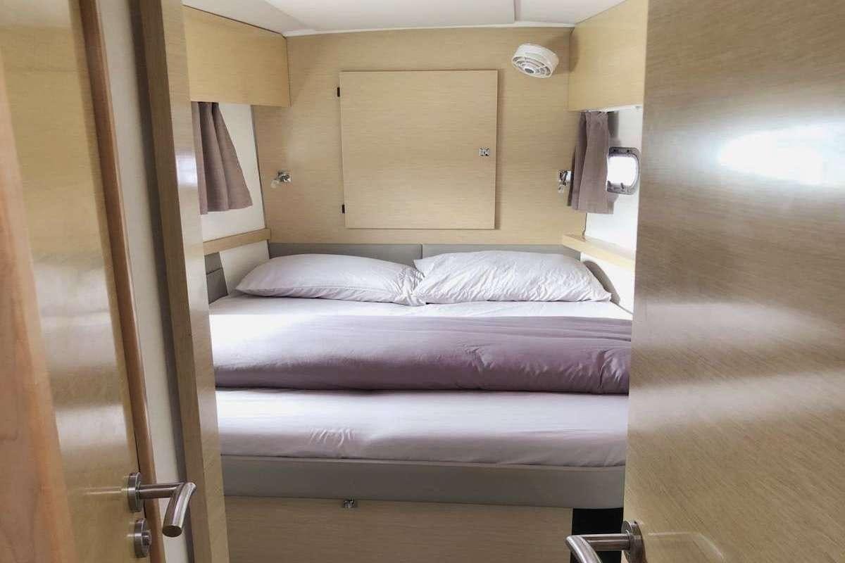 a bed with a purple sheet aboard IREMIA Yacht for Charter