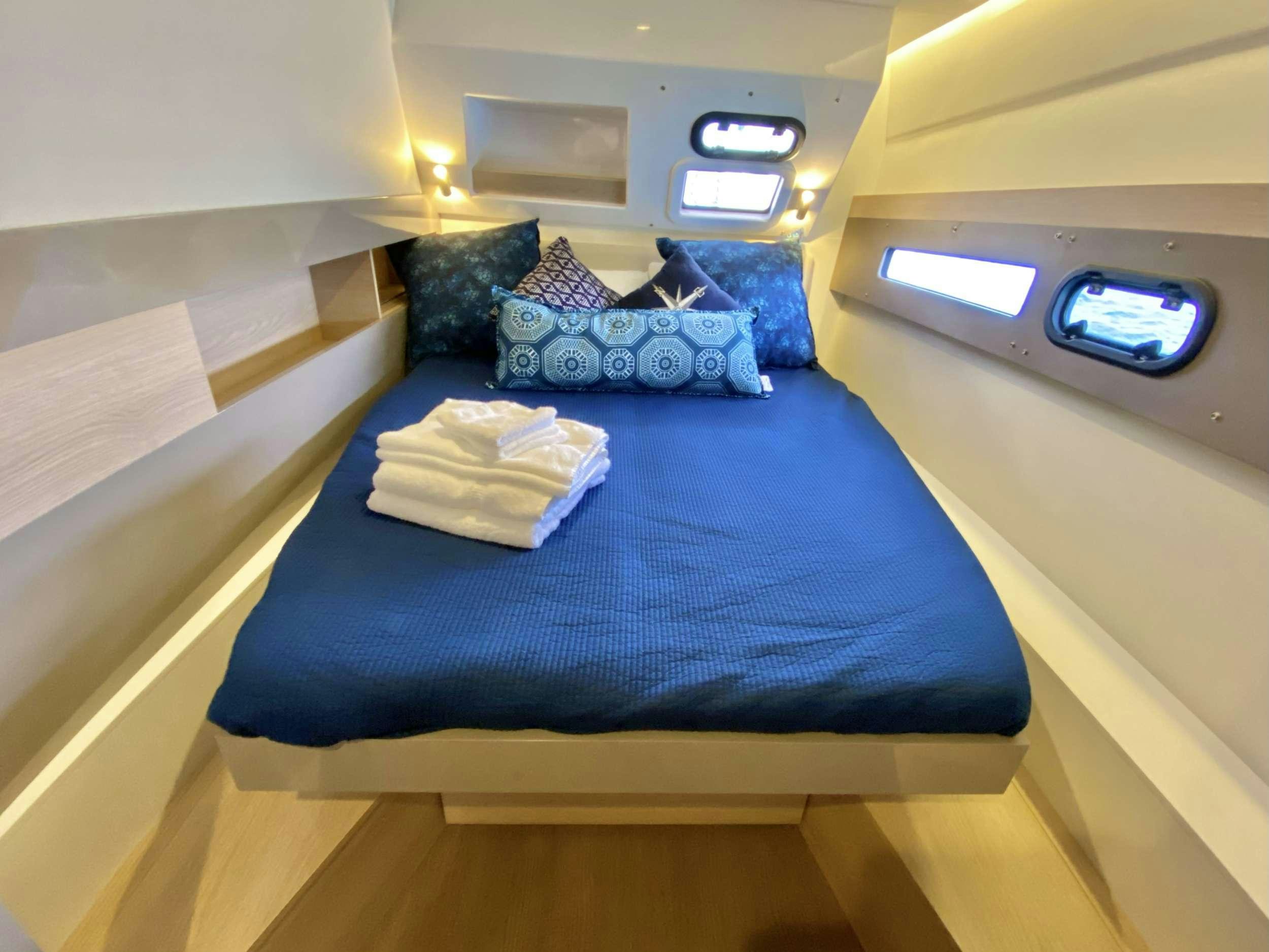 a bed with blue sheets aboard FREESTYLE Yacht for Charter