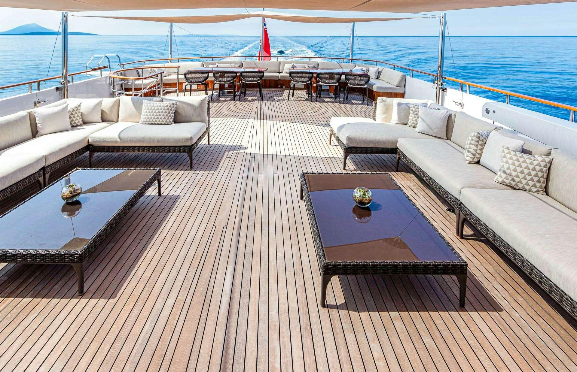 a deck with a table and a couch and a pool aboard MIRAGE Yacht for Charter