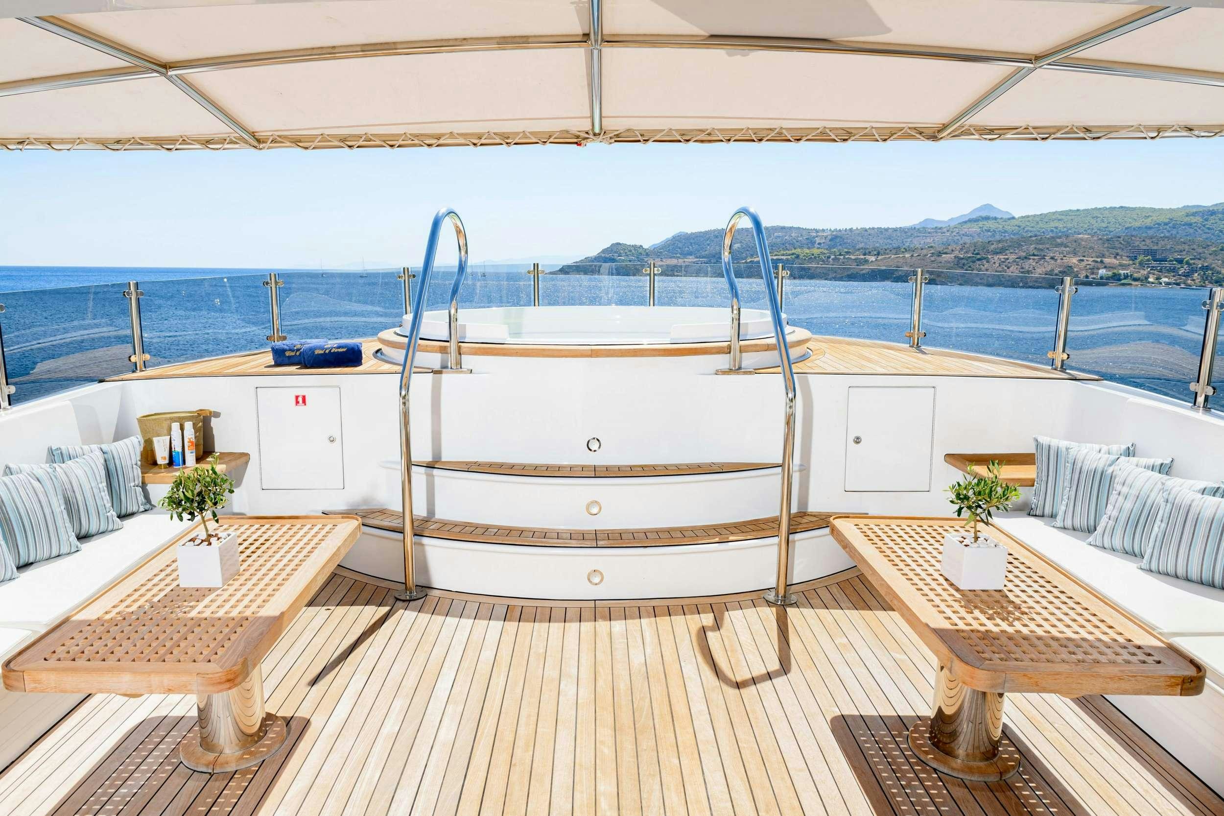 a deck with a table and chairs on it aboard WIND OF FORTUNE Yacht for Charter