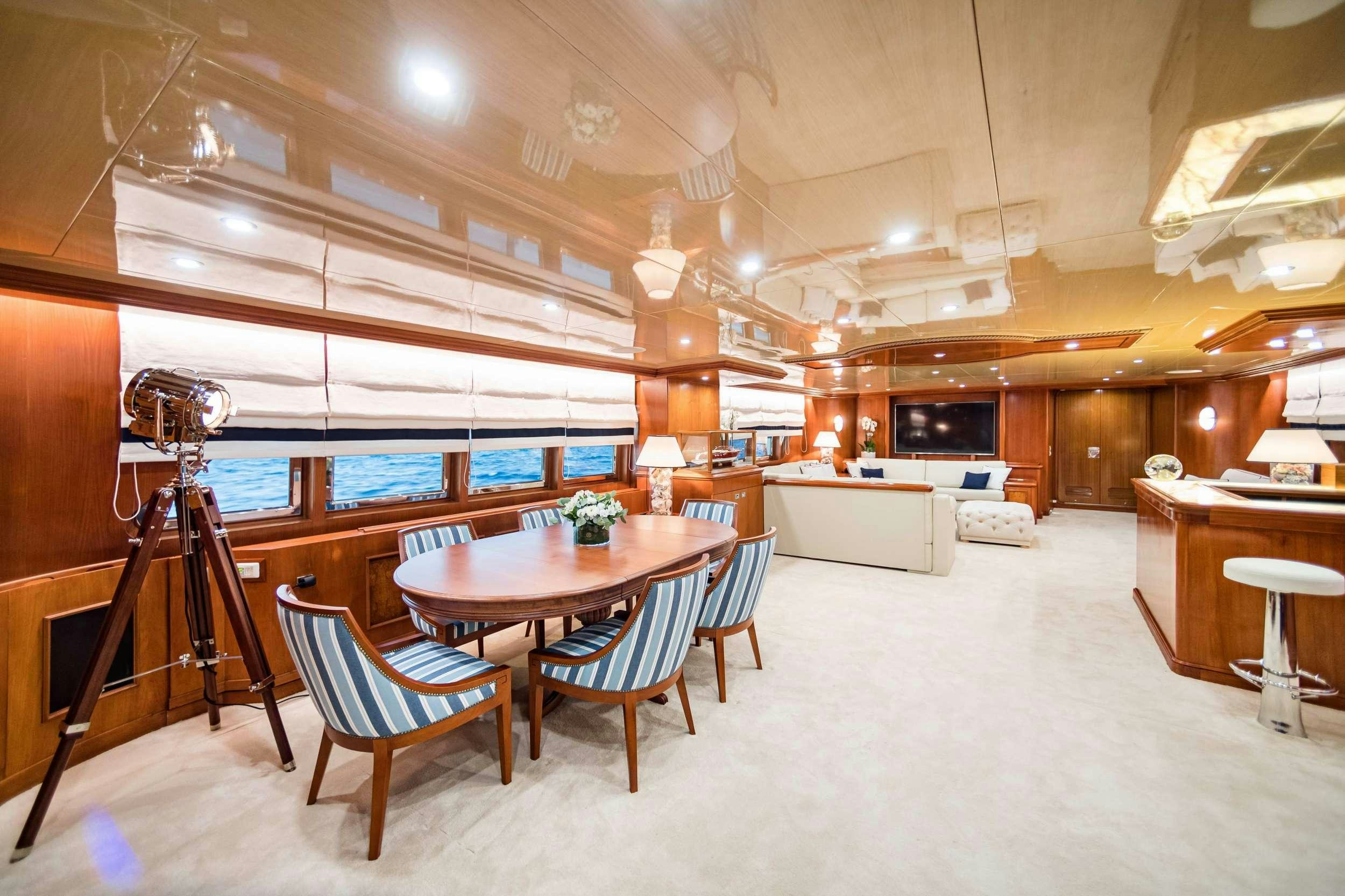a room with a table chairs and a camera aboard WIND OF FORTUNE Yacht for Charter