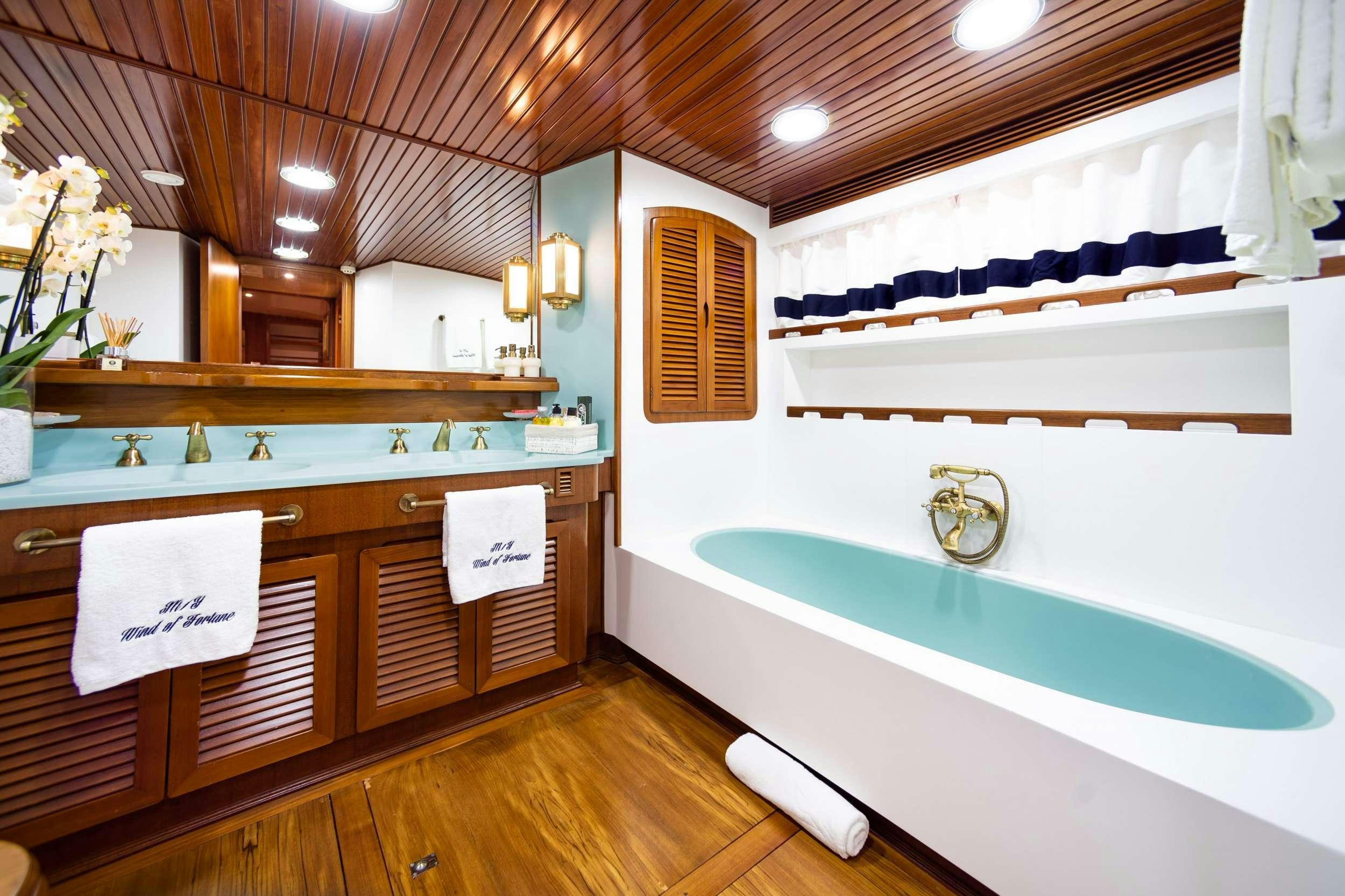 a bathroom with a tub sink and cabinets aboard WIND OF FORTUNE Yacht for Charter