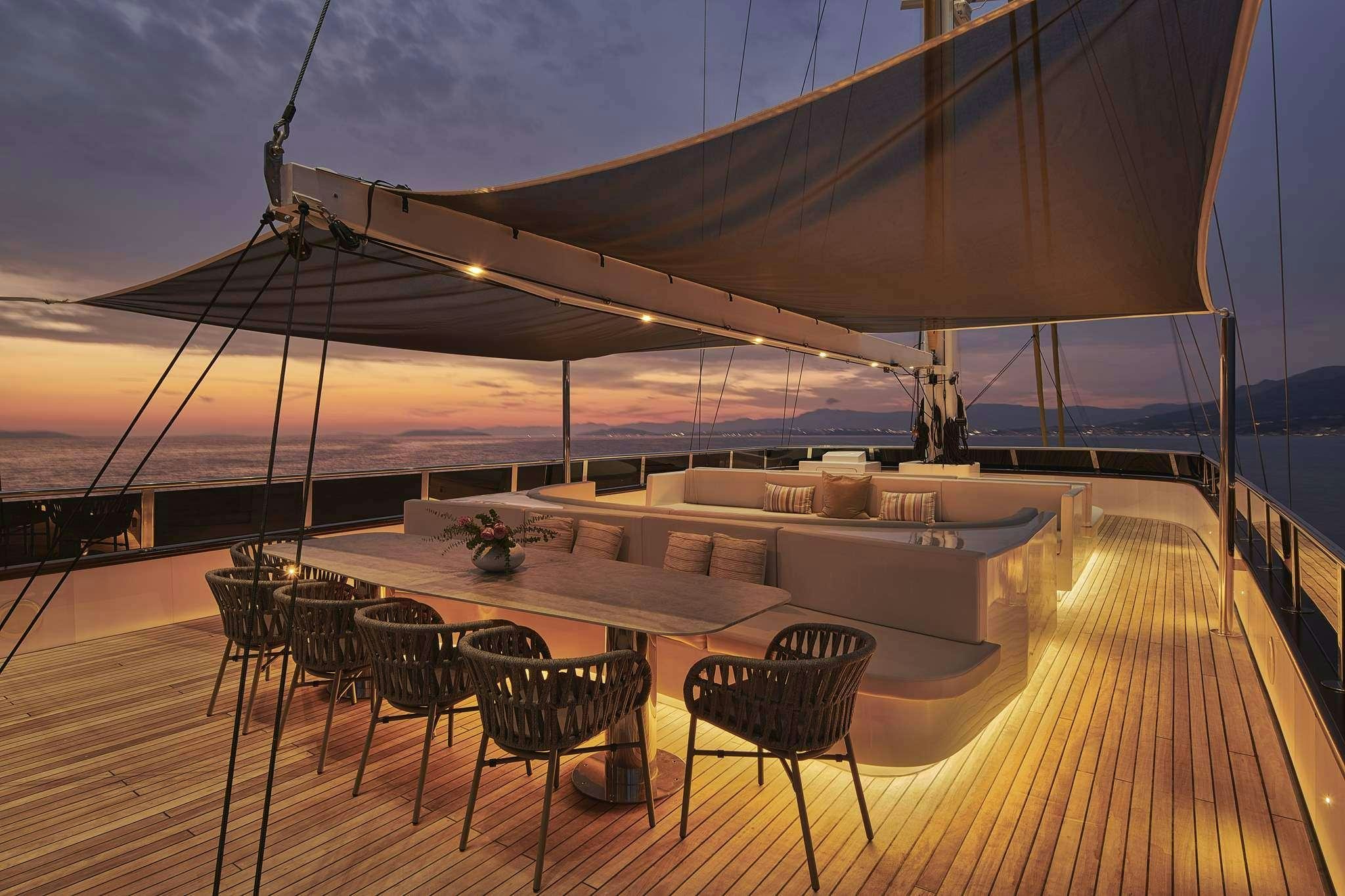 a deck with tables and chairs aboard ANIMA MARIS Yacht for Charter
