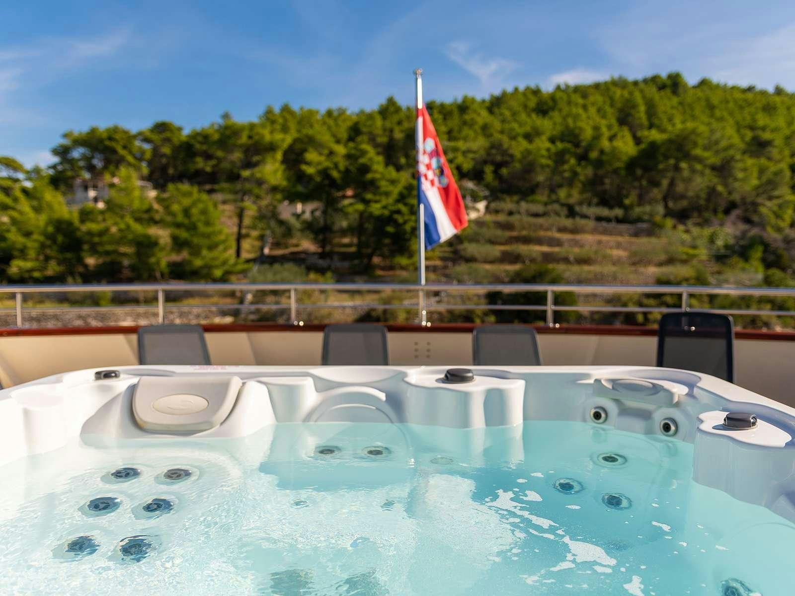a pool with a flag on the side aboard YOLO Yacht for Charter
