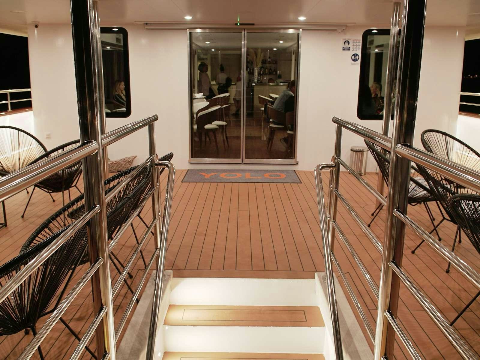 a room with chairs and a table aboard YOLO Yacht for Charter