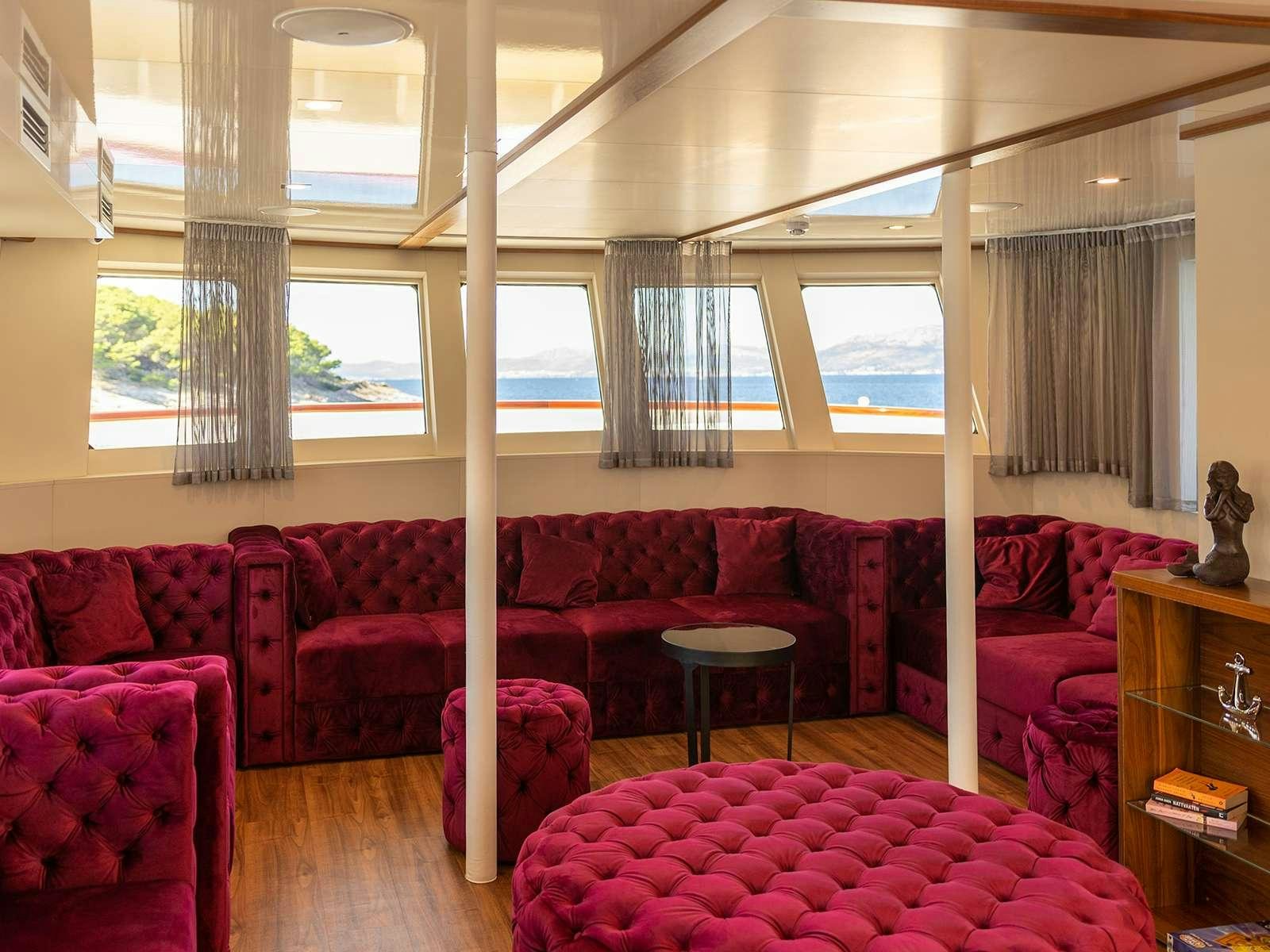 a living room with a red couch aboard YOLO Yacht for Charter