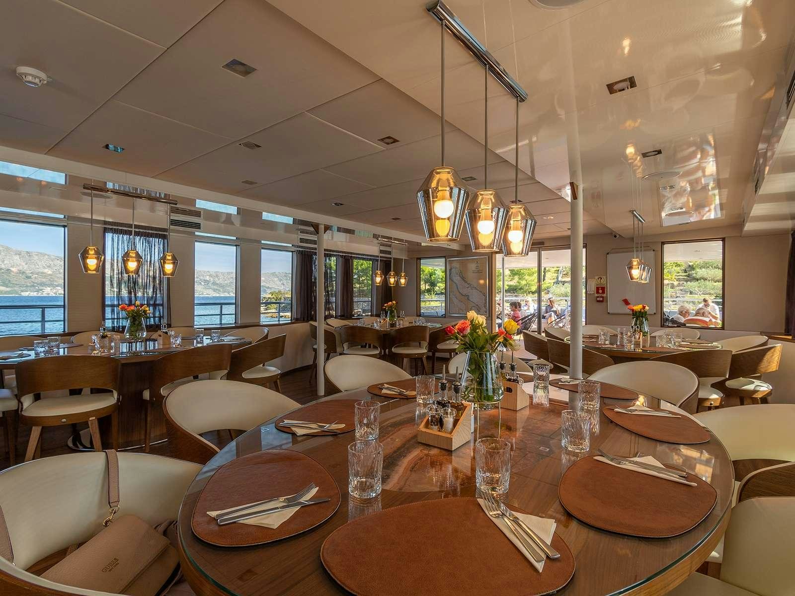 a restaurant with tables and chairs aboard YOLO Yacht for Charter