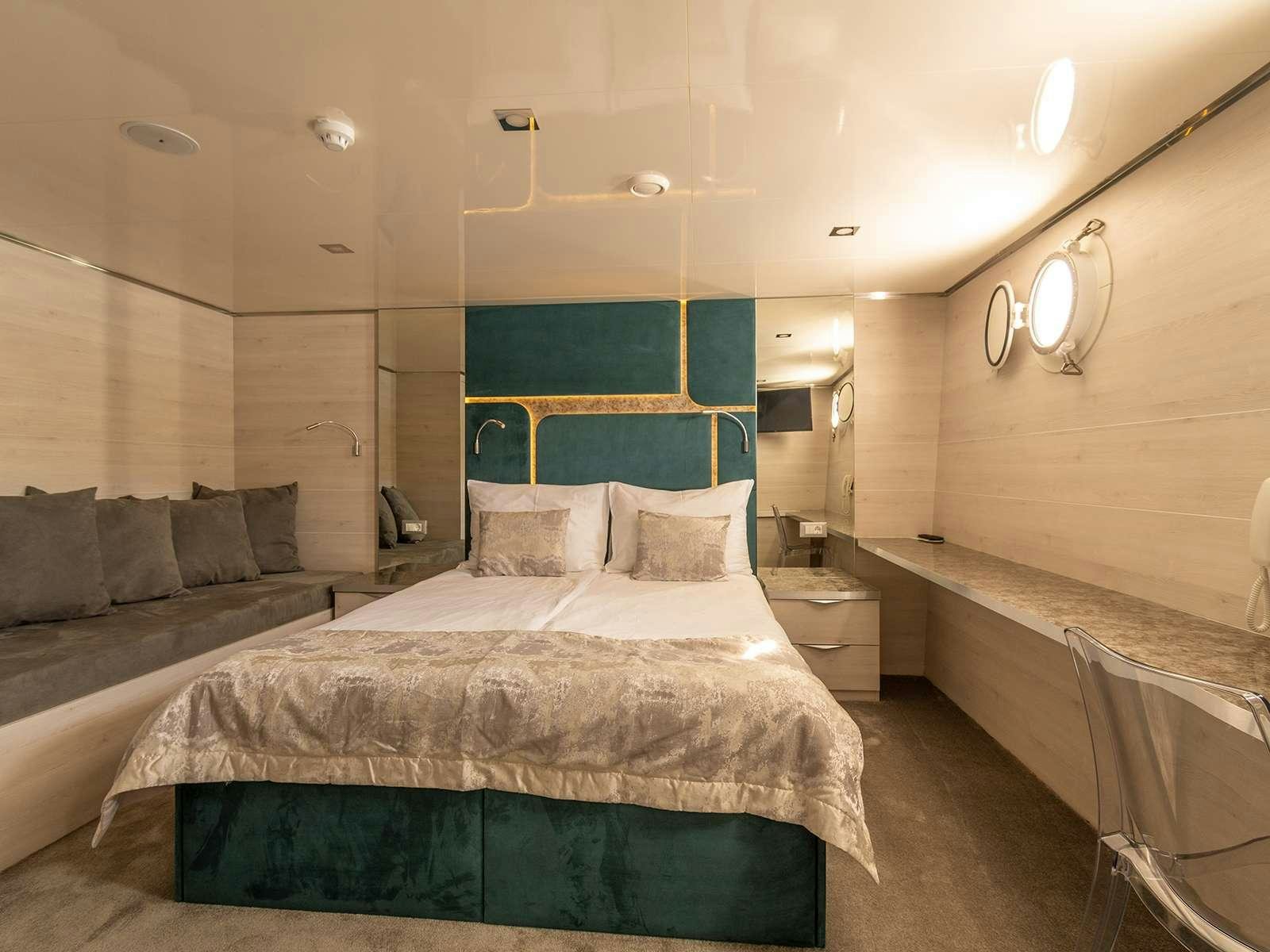 a room with a bed and a bathtub aboard YOLO Yacht for Charter