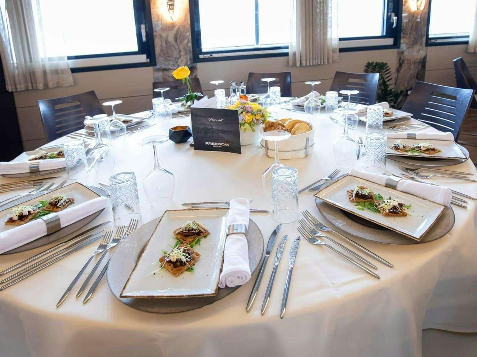 a table set with plates and silverware aboard FREEDOM Yacht for Charter