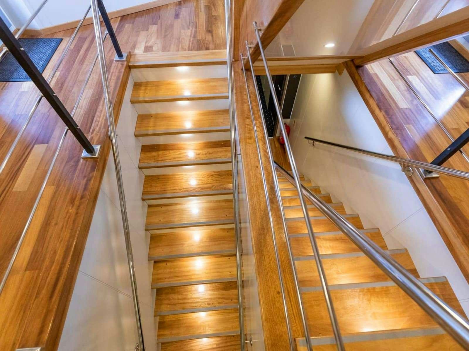 a wooden staircase with a railing aboard FREEDOM Yacht for Charter
