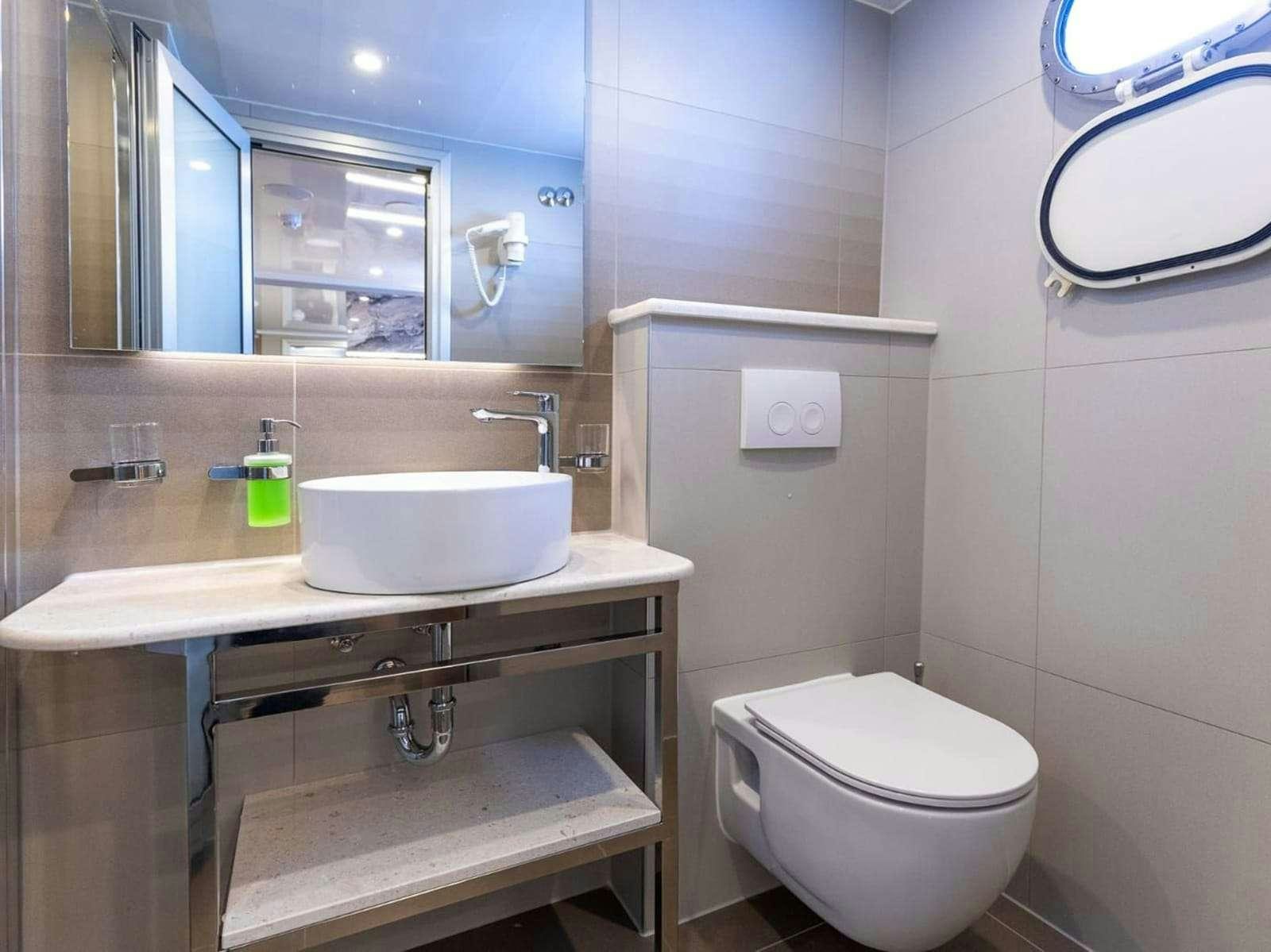 a bathroom with a sink toilet and a mirror aboard FREEDOM Yacht for Charter