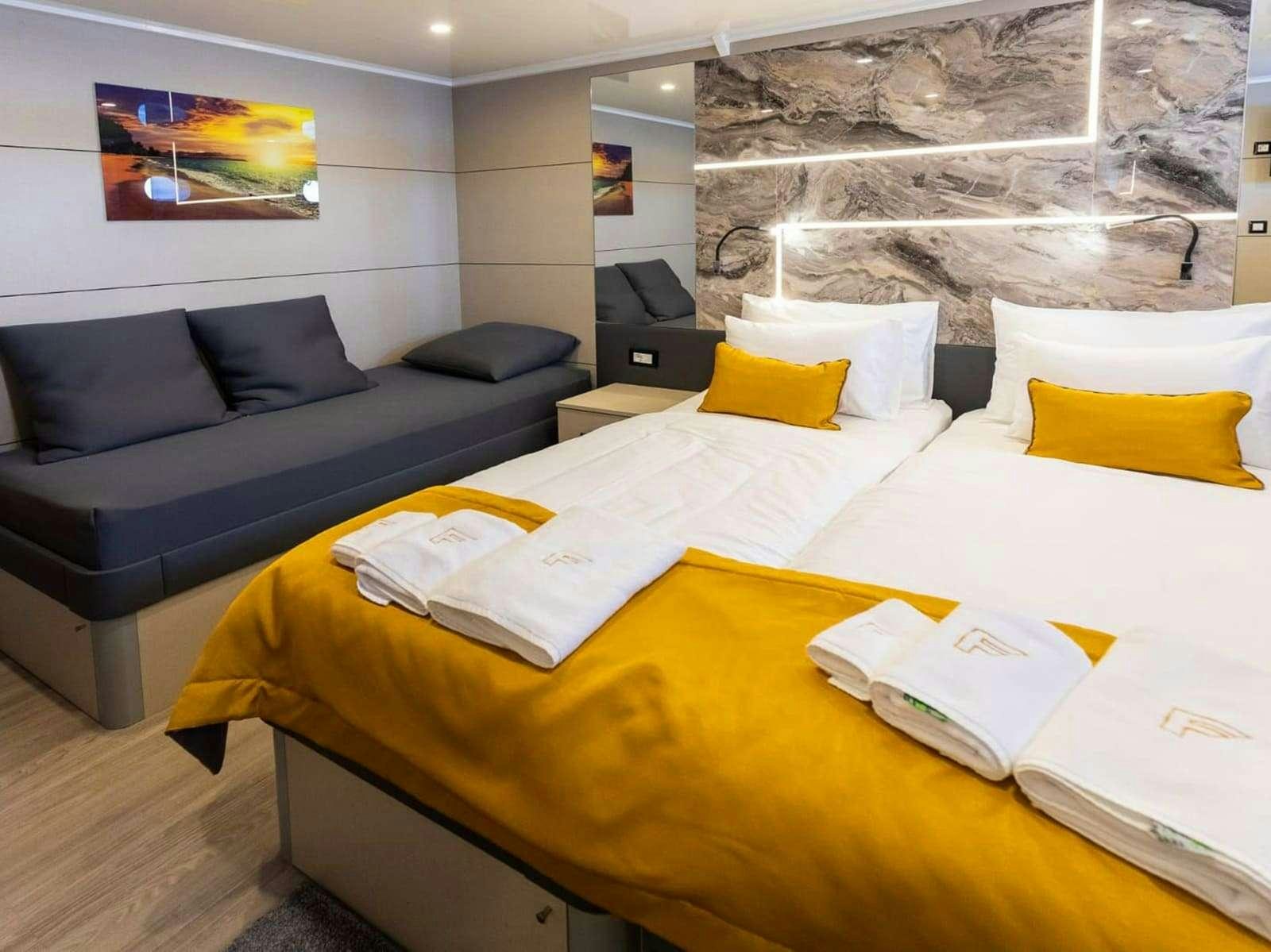 a bed with a couch and a table aboard FREEDOM Yacht for Charter