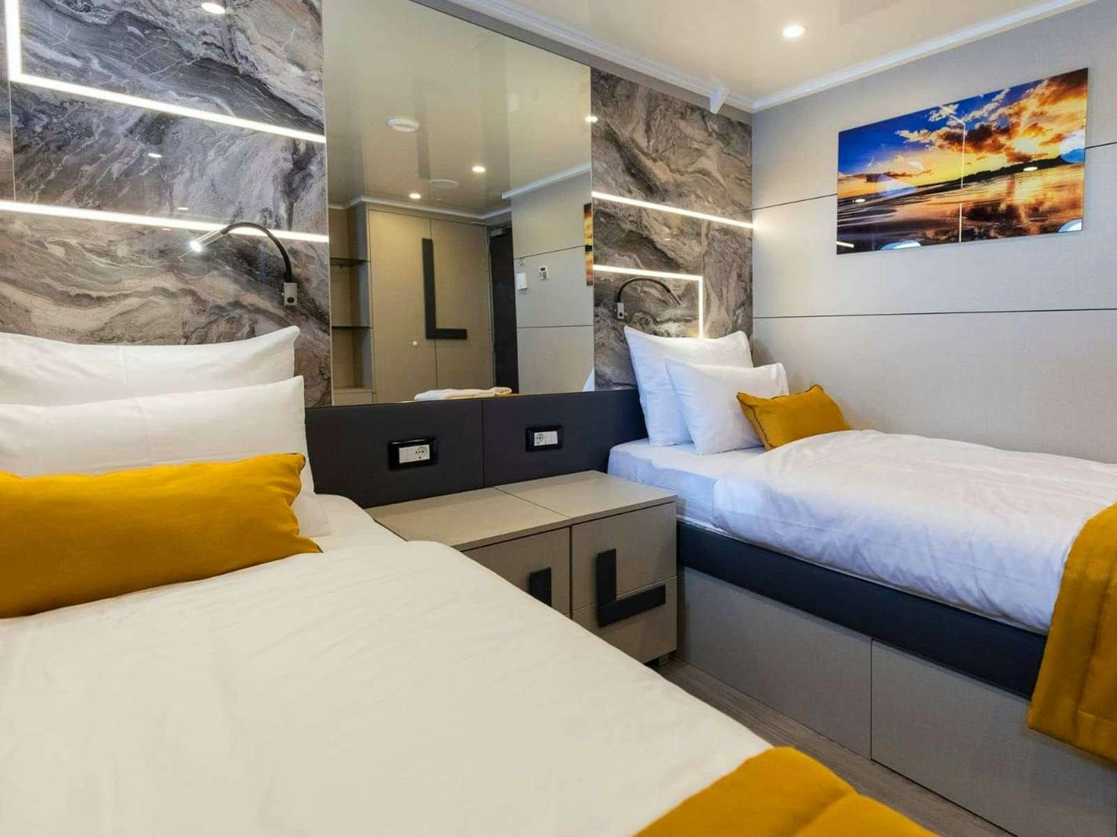 a room with a bed and a television aboard FREEDOM Yacht for Charter