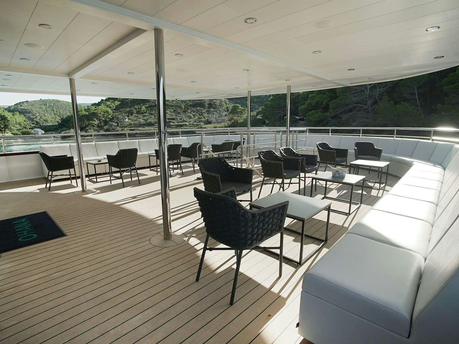 a room with chairs and tables aboard OHANA Yacht for Charter