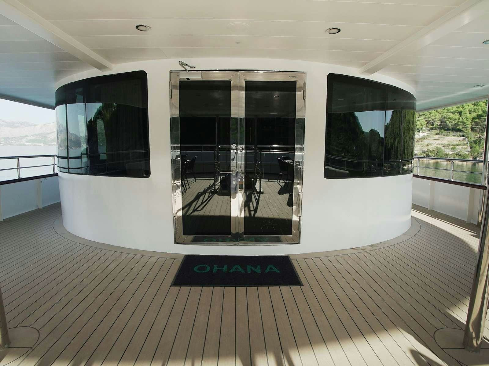 a large white room with a large glass door and a deck aboard OHANA Yacht for Charter