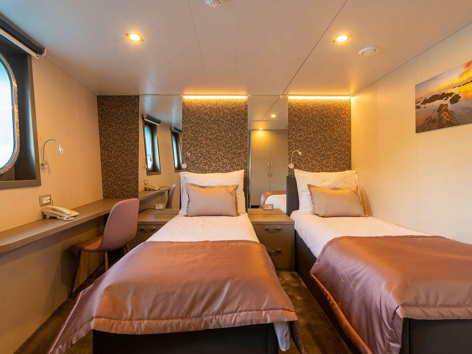 a couple of beds in a hotel room aboard OHANA Yacht for Charter