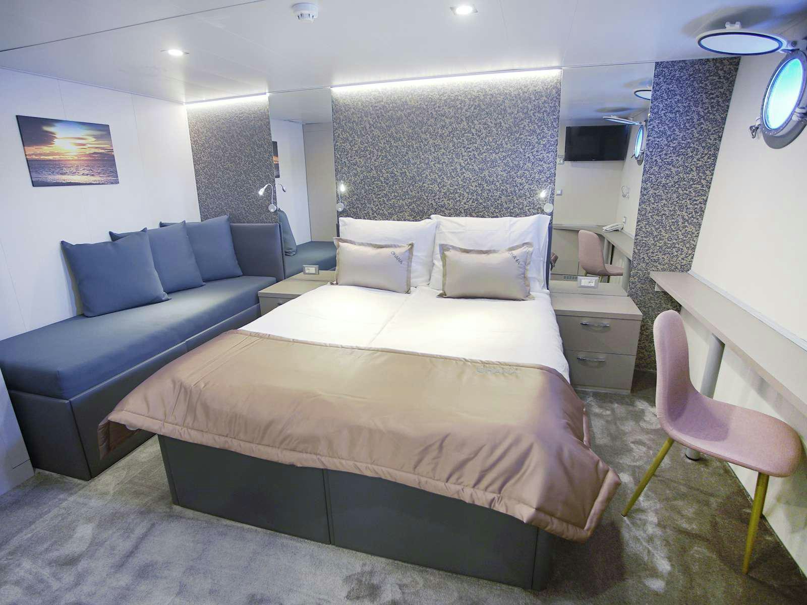 a room with a bed and a couch aboard OHANA Yacht for Charter
