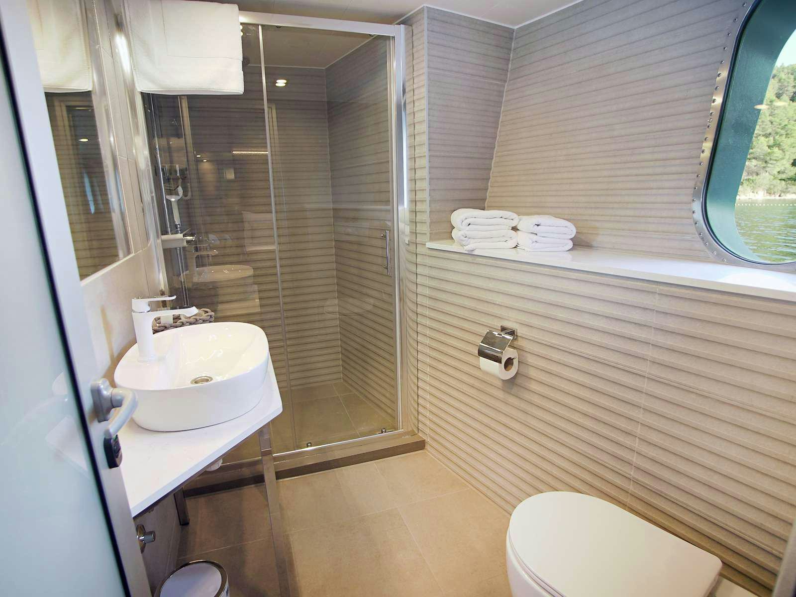 a bathroom with a glass shower aboard OHANA Yacht for Charter