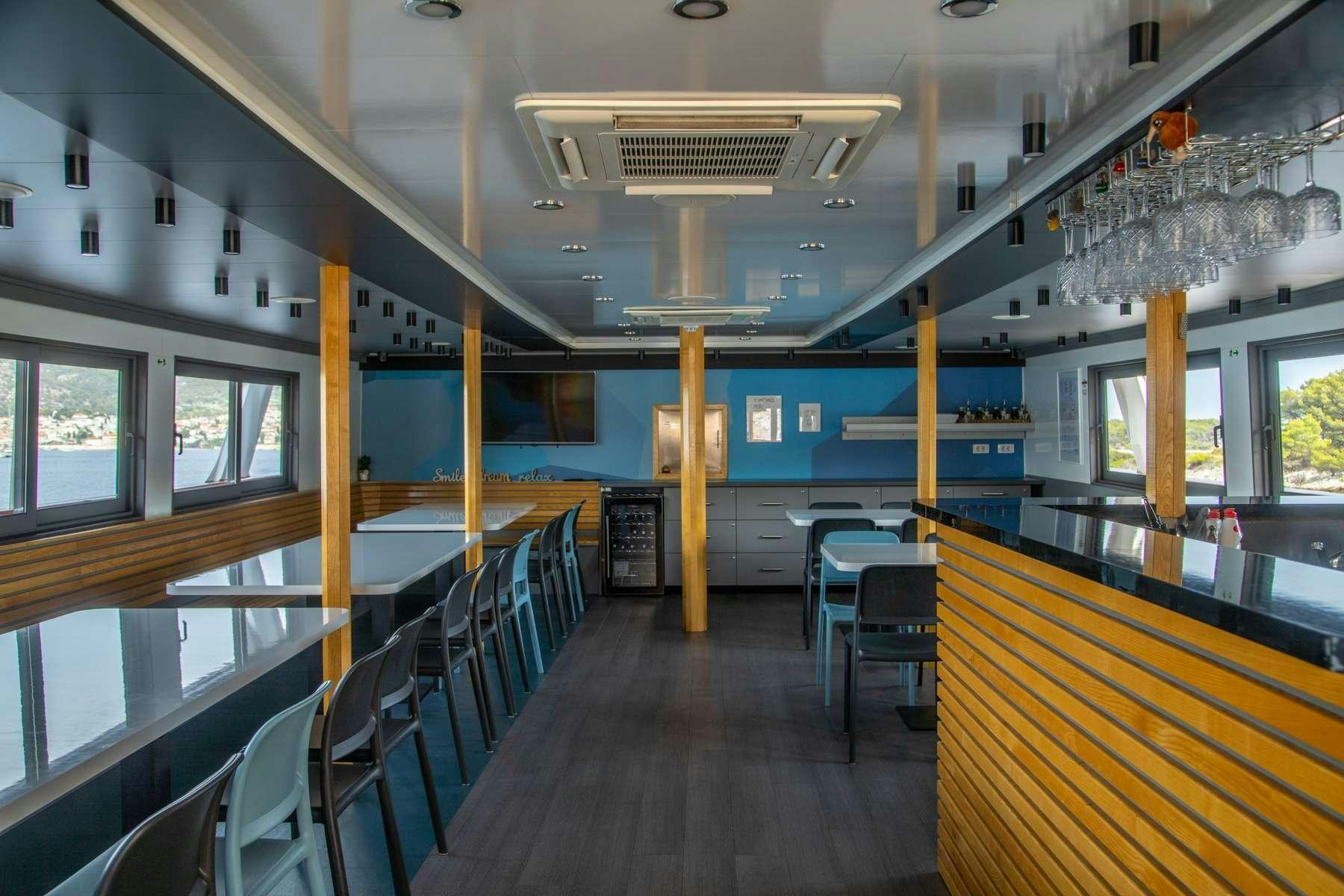 a room with tables and chairs aboard ALMISSA Yacht for Charter