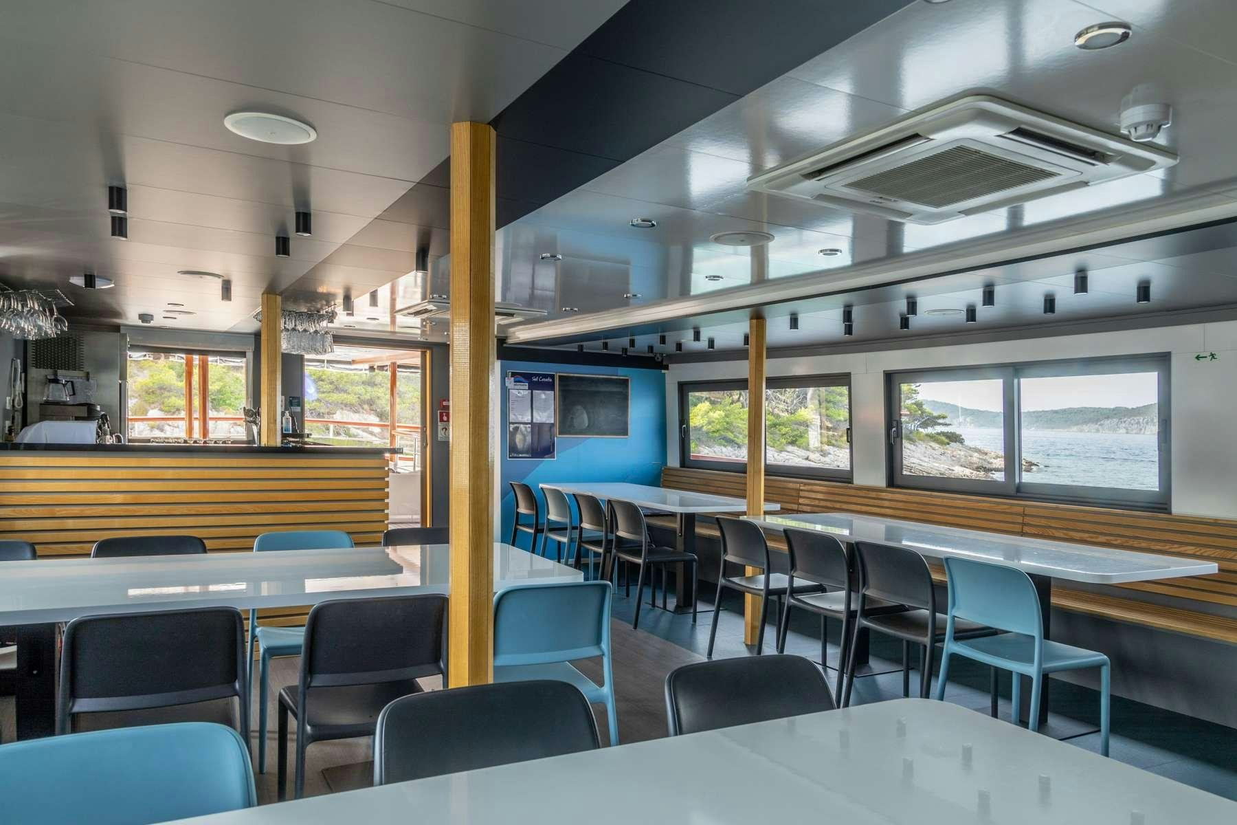 a room with tables and chairs aboard ALMISSA Yacht for Charter