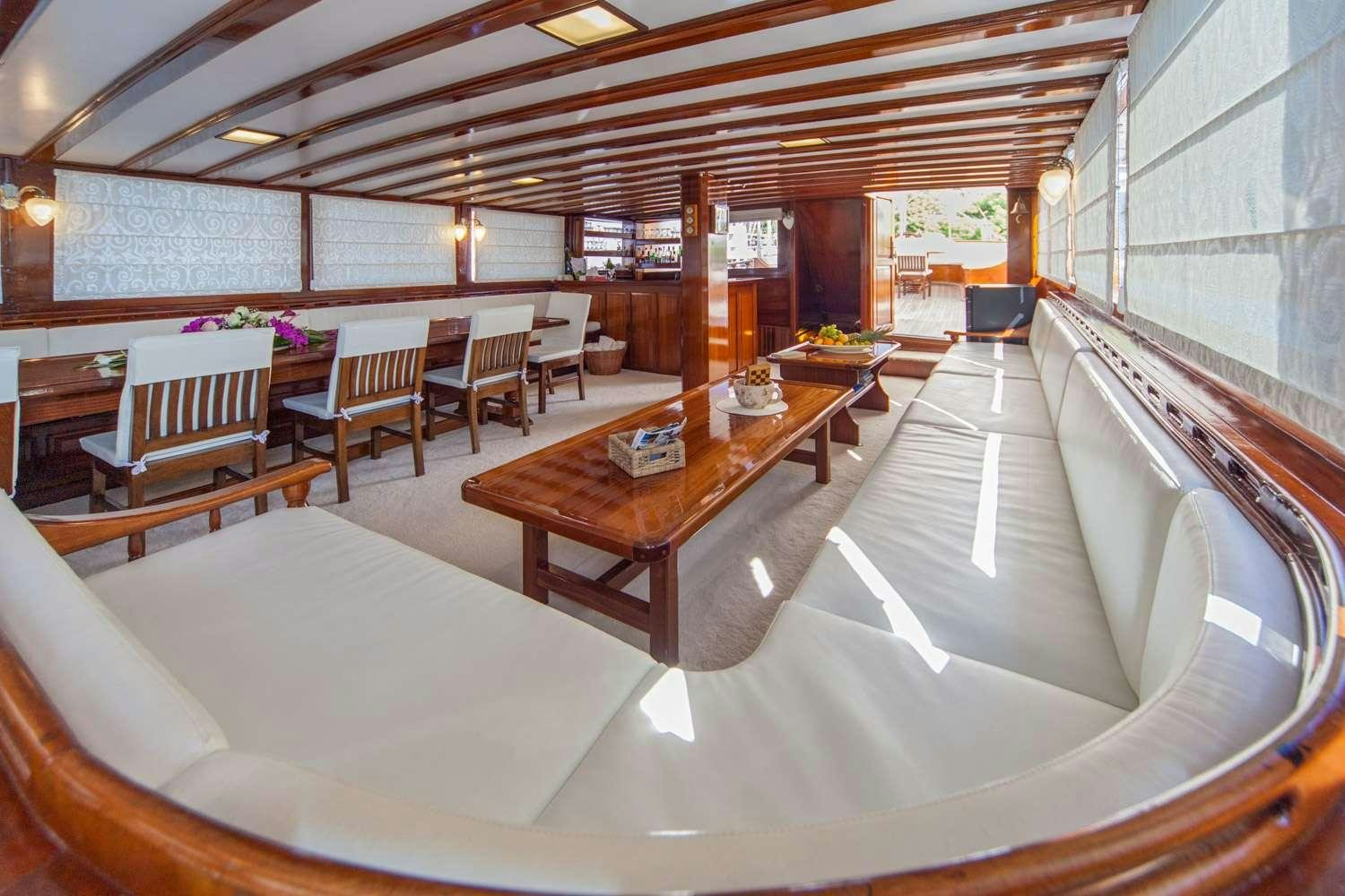 a large room with a table and chairs aboard STELLA MARIS Yacht for Charter