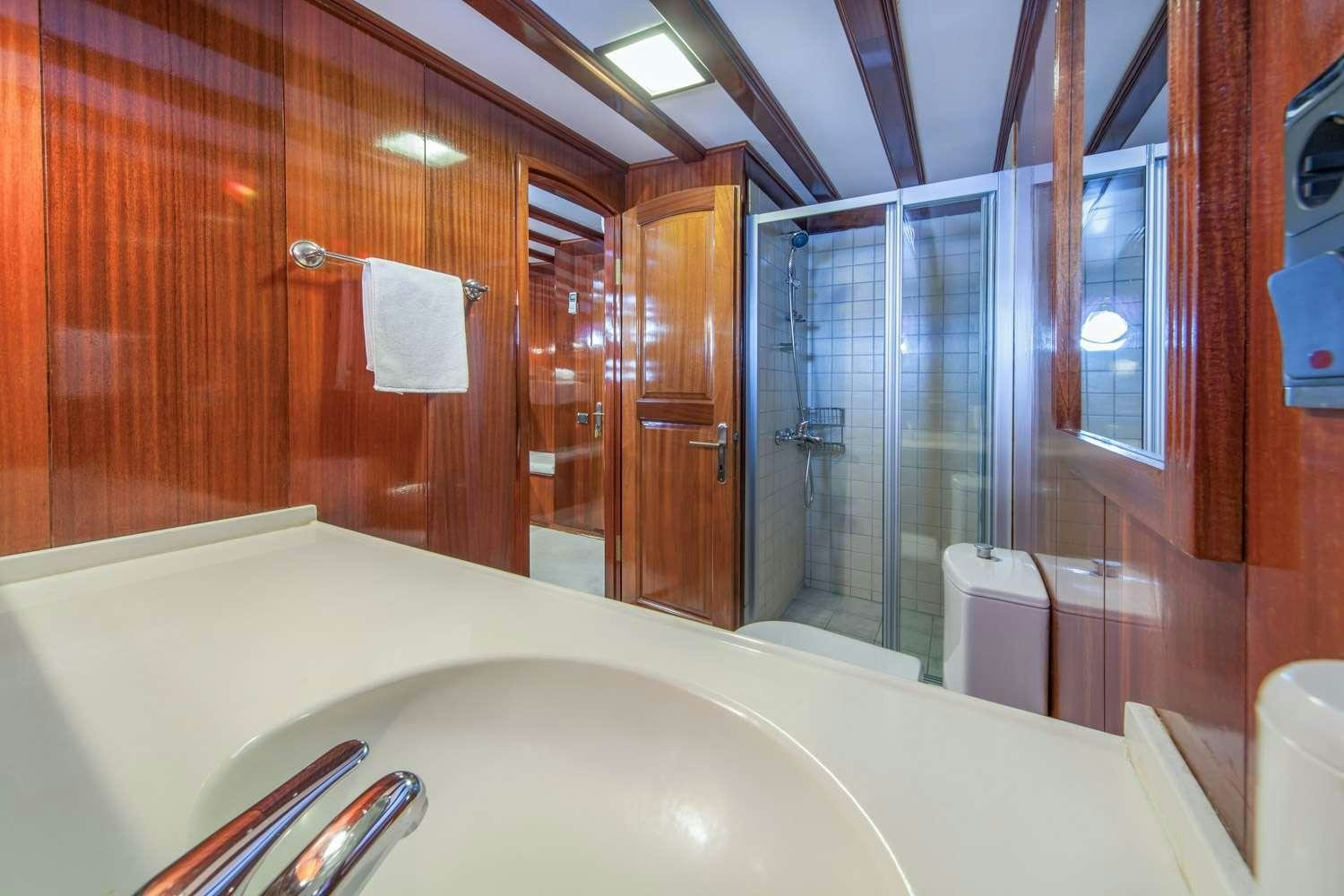a bathroom with a bathtub and shower aboard STELLA MARIS Yacht for Charter