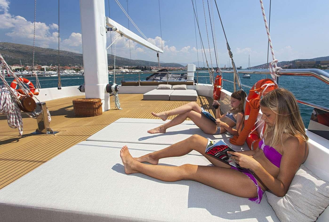a group of people sitting on a deck on a boat aboard NAVILUX Yacht for Charter