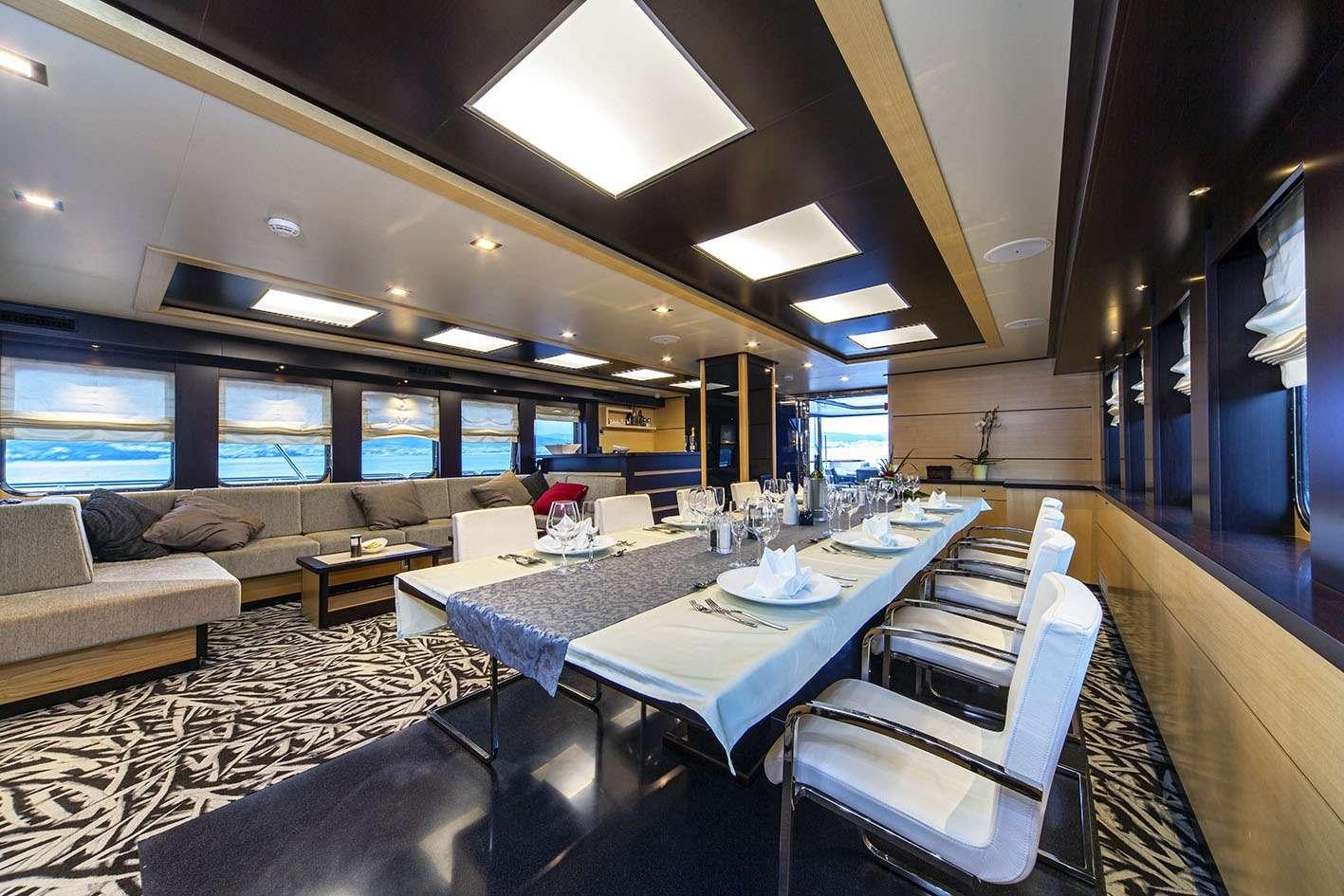 a room with a table and chairs aboard NAVILUX Yacht for Charter
