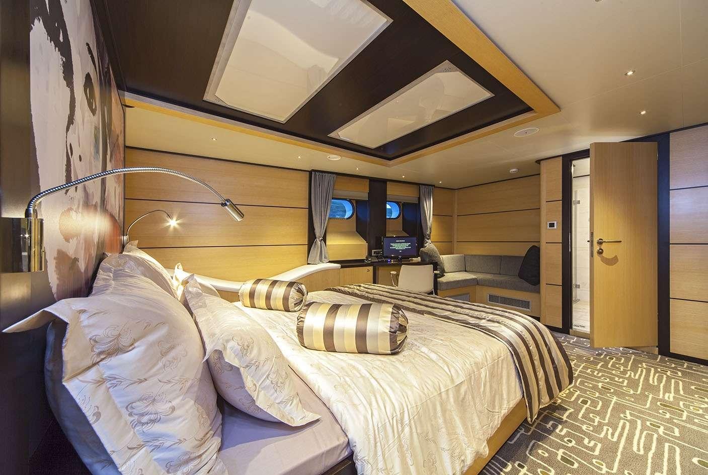 a room with a bed and a tv aboard NAVILUX Yacht for Charter