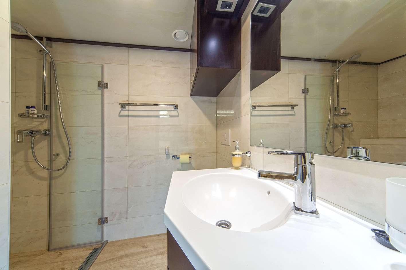 a bathroom with a sink and a shower aboard NAVILUX Yacht for Charter