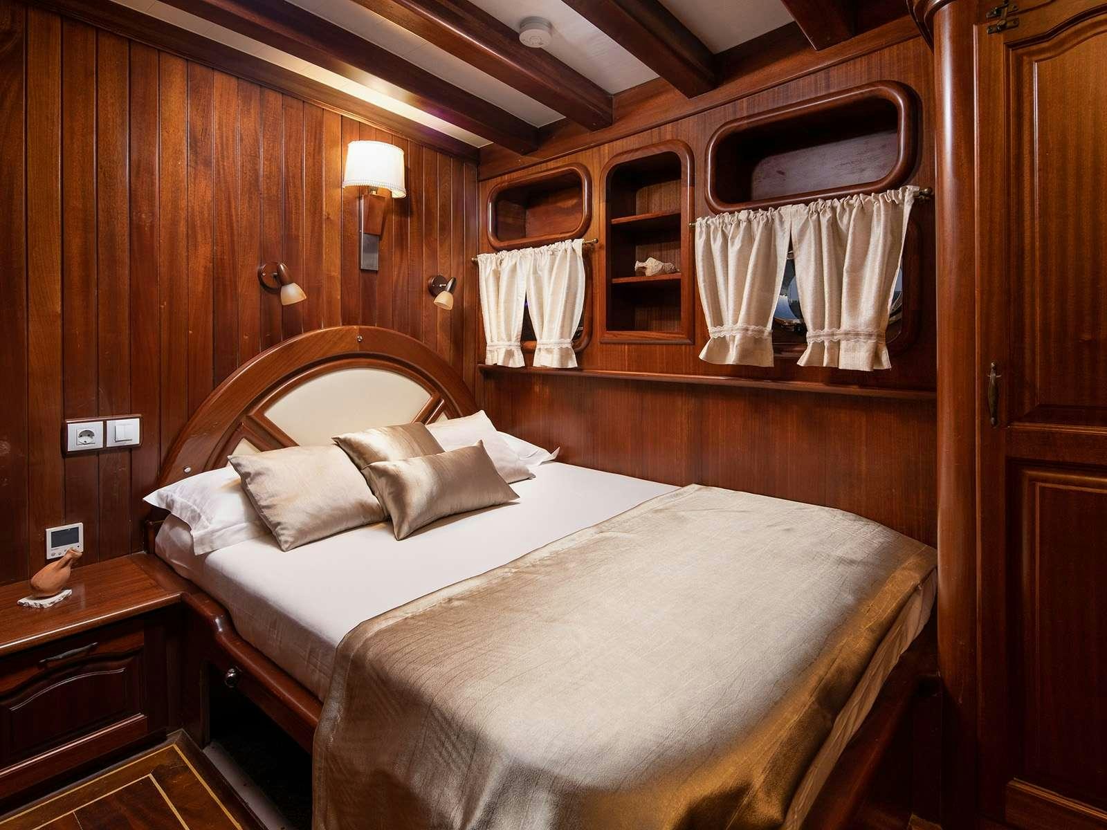 a bed with white sheets aboard GULET NOSTRA VITA Yacht for Charter