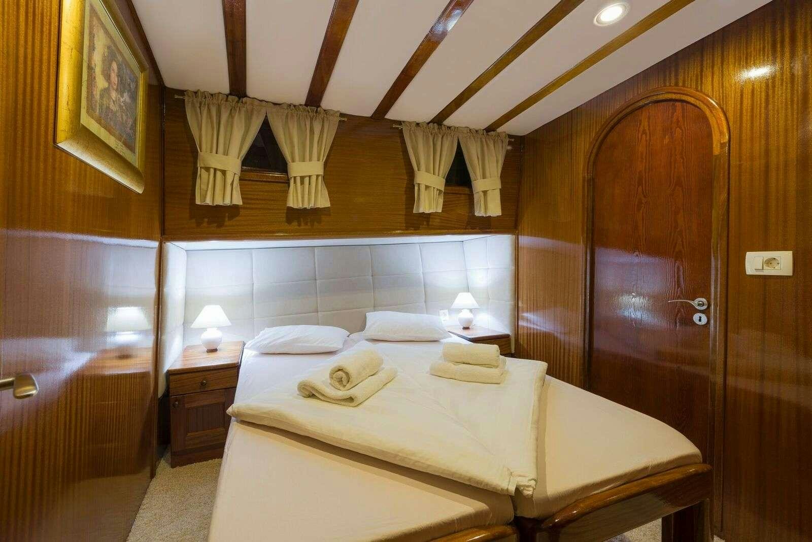 a bedroom with a bed and a wood door aboard LINDA Yacht for Charter