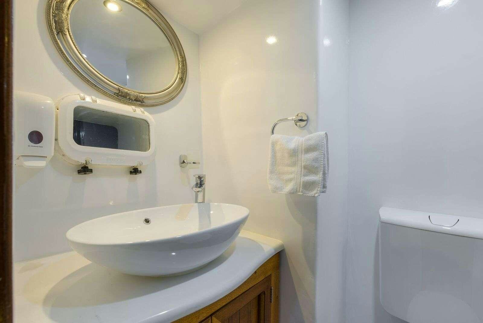 a bathroom with a sink and a mirror aboard LINDA Yacht for Charter